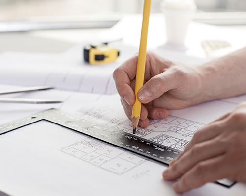 home design man drawing up home plans with pencil and ruler